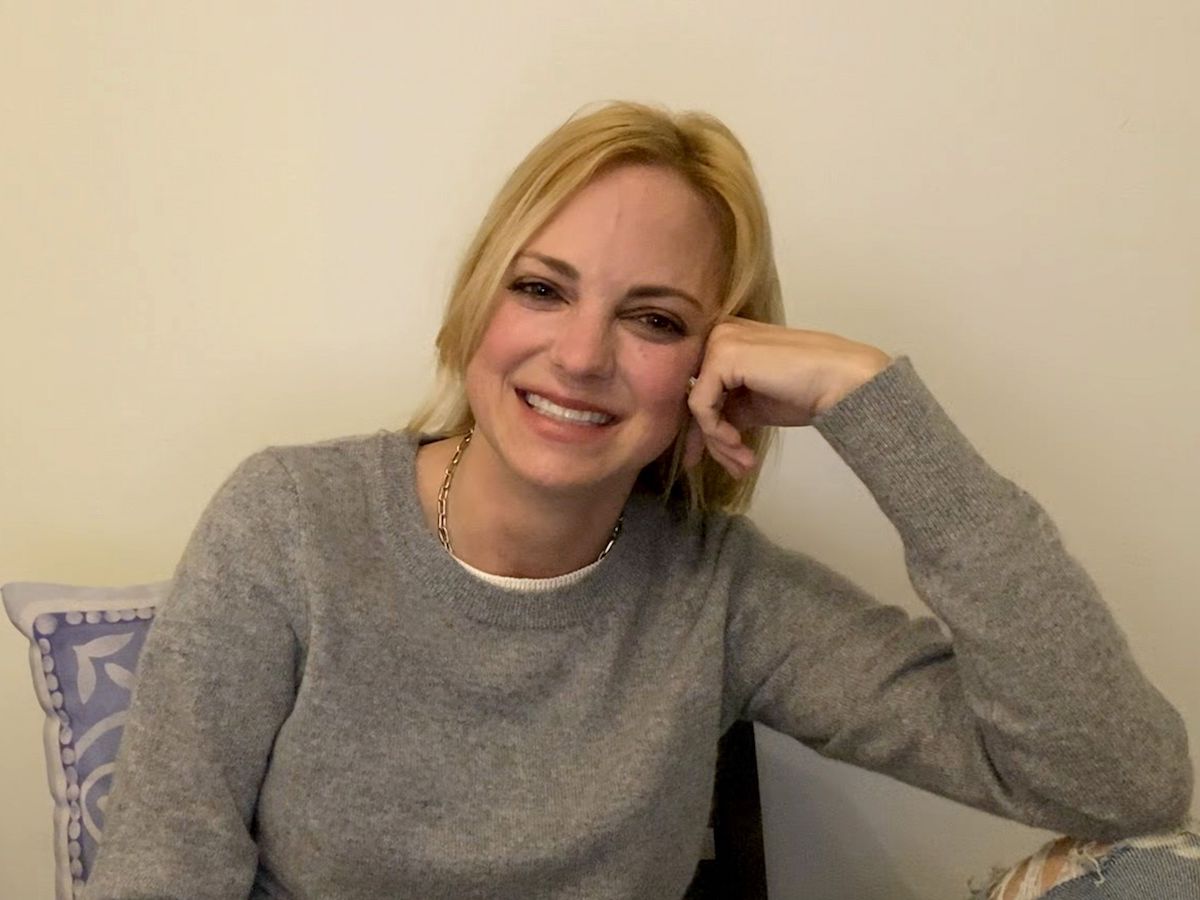 screengrab of Anna Faris on webcam in a grey sweater resting her head on her hand