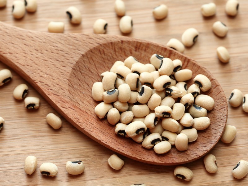 stock photo of black-eyed peas on a wooden spoon and table