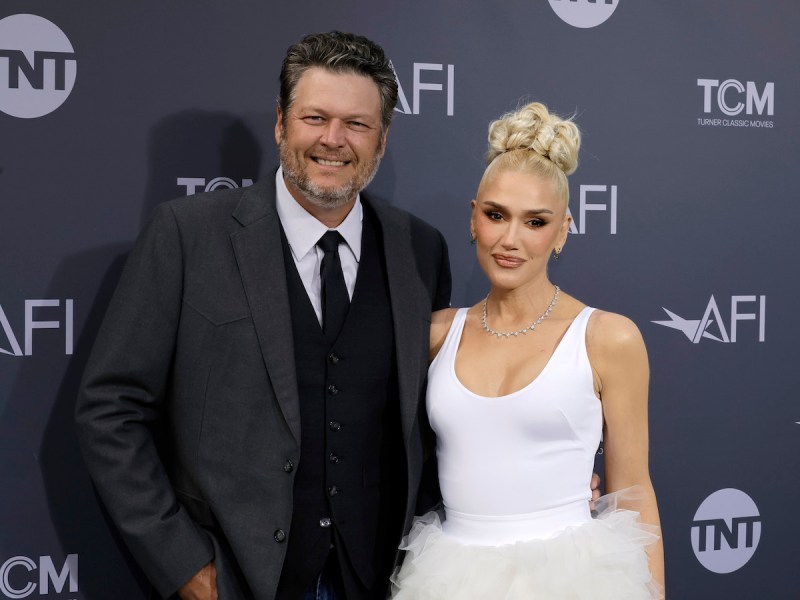 Blake Shelton in a charcoal suit with Gwen Stefani in a white dress