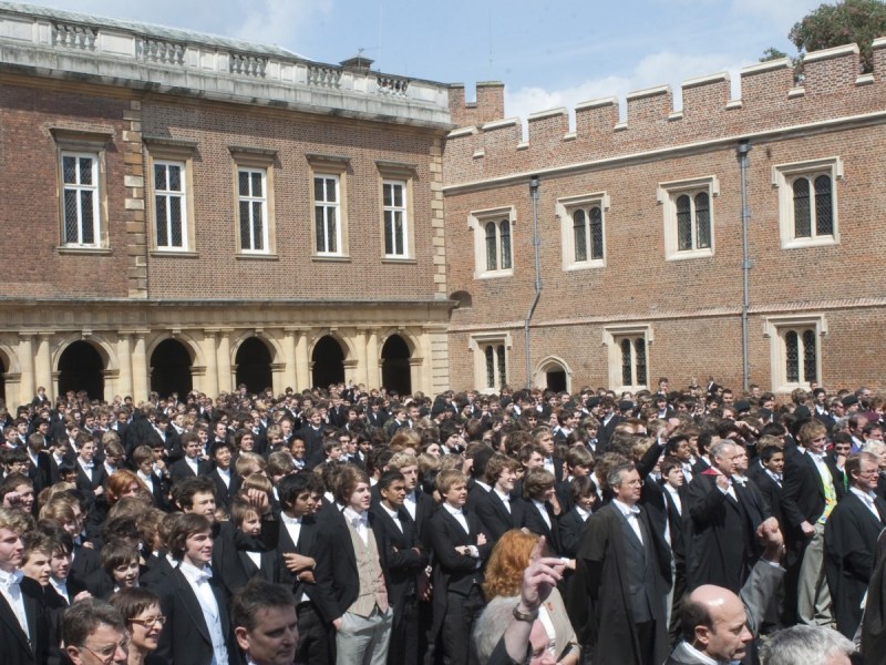 A large grad of presumed graduates stands in front of Eton College