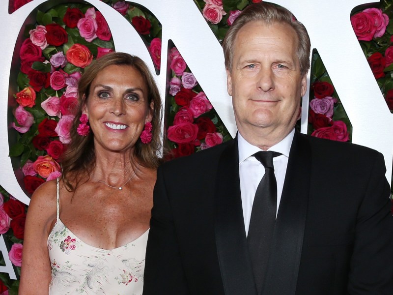 Jeff Daniels (R) and Kathleen Rosemary Treado smiling against red and pink floral backdrop