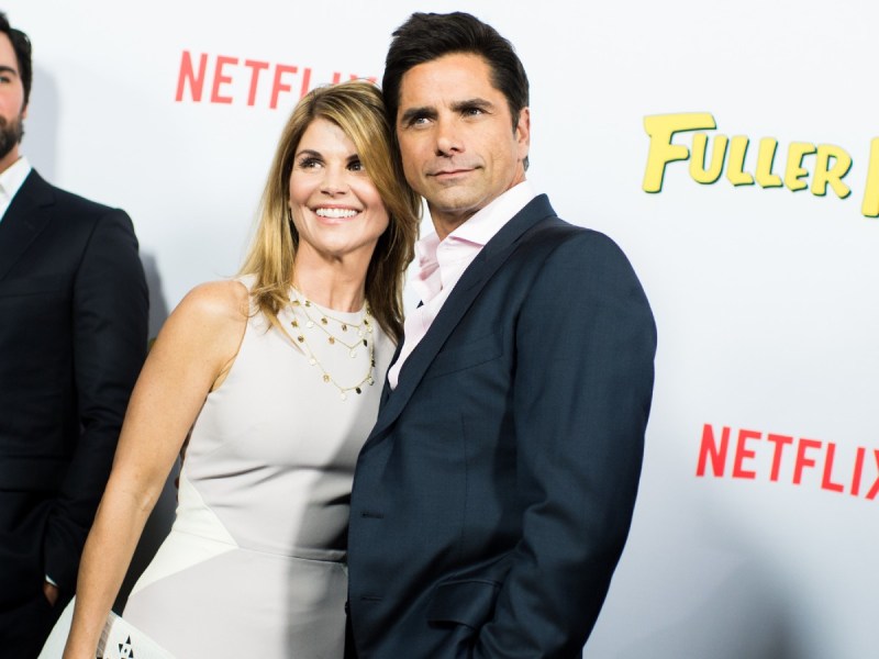 Lori Loughlin (L) in white dress standing next to John Stamos