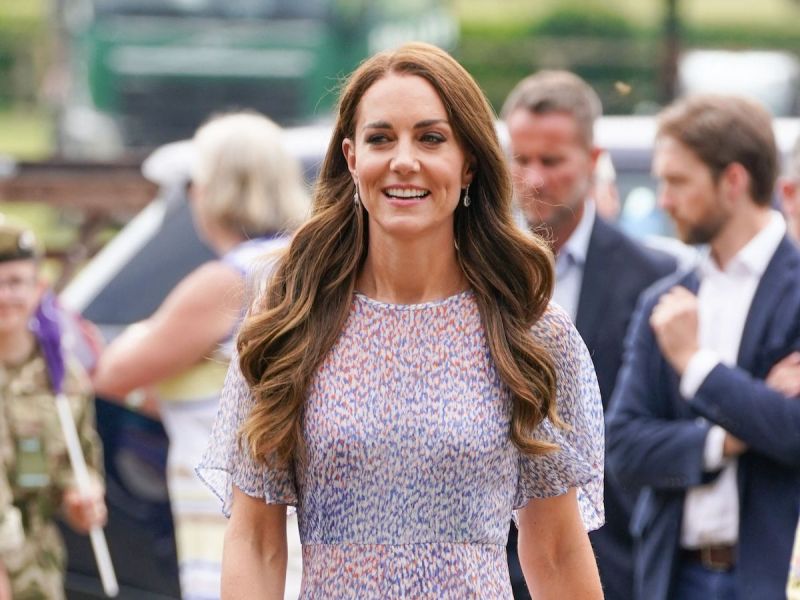 Kate Middleton smiling in a white and black summer dress outside