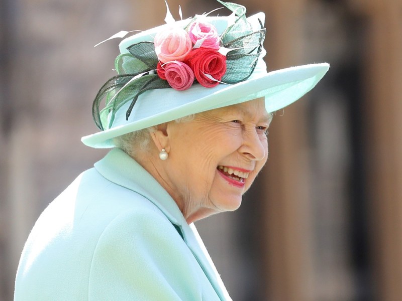 Queen Elizabeth smiles in mint blue/green suit and matching hat