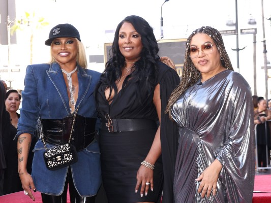 The women of Salt-N-Pepa smiling together on a red carpet
