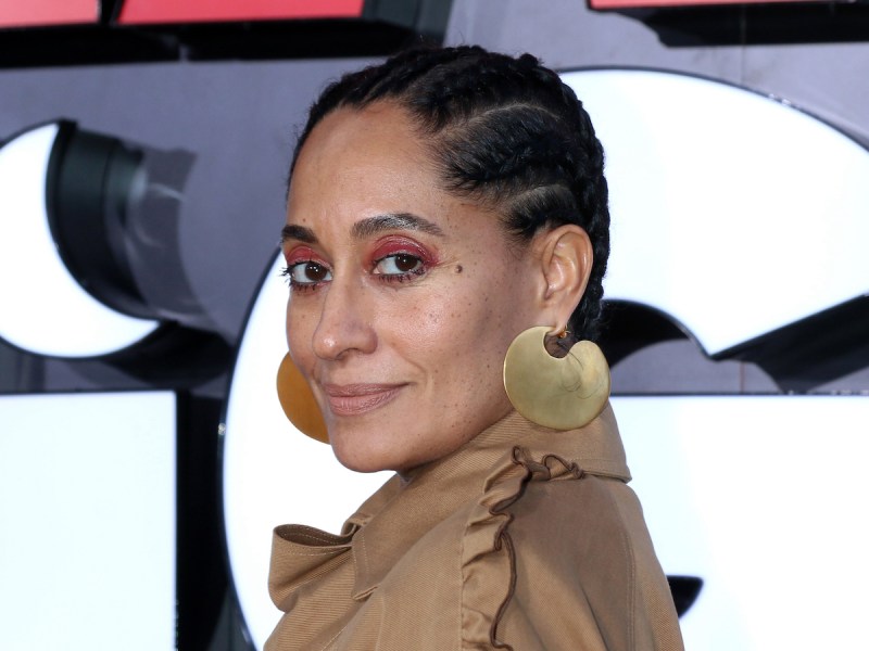close up of Tracee Ellis Ross looking over her shoulder in a tan blouse
