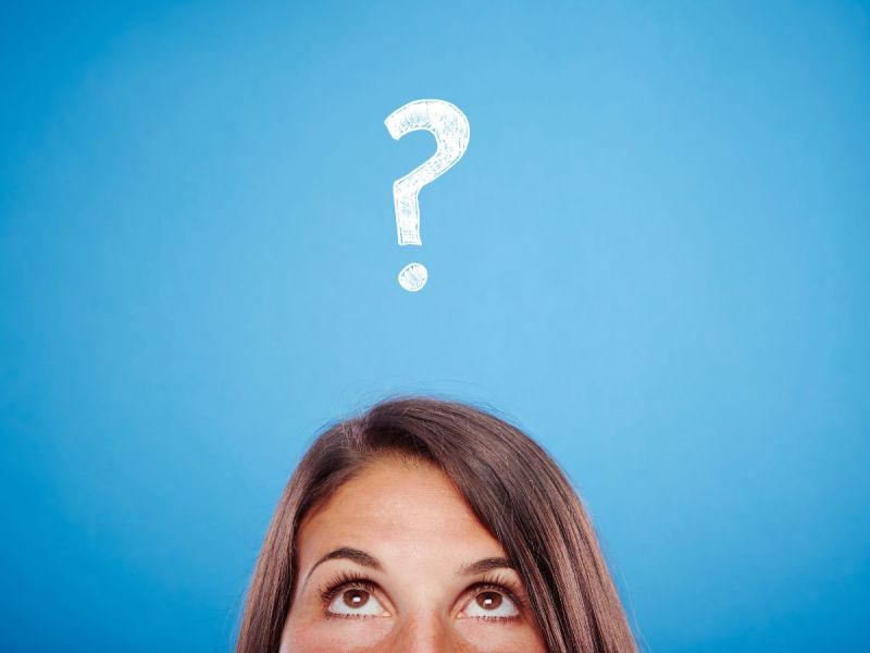 Image of woman from nose up looking up toward white question mark on blue background