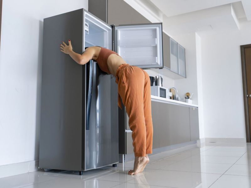 Woman sticking her head in freezer