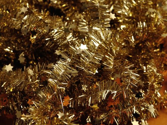 Close-up of gold Christmas tree tinsel with stars interspersed