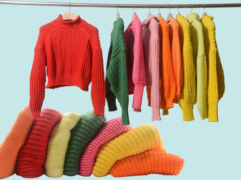 sweaters folded in a tipped-over pile and hanging hangers