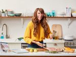 Whole30 founder Melissa Urban smiles and preps food in the kitchen