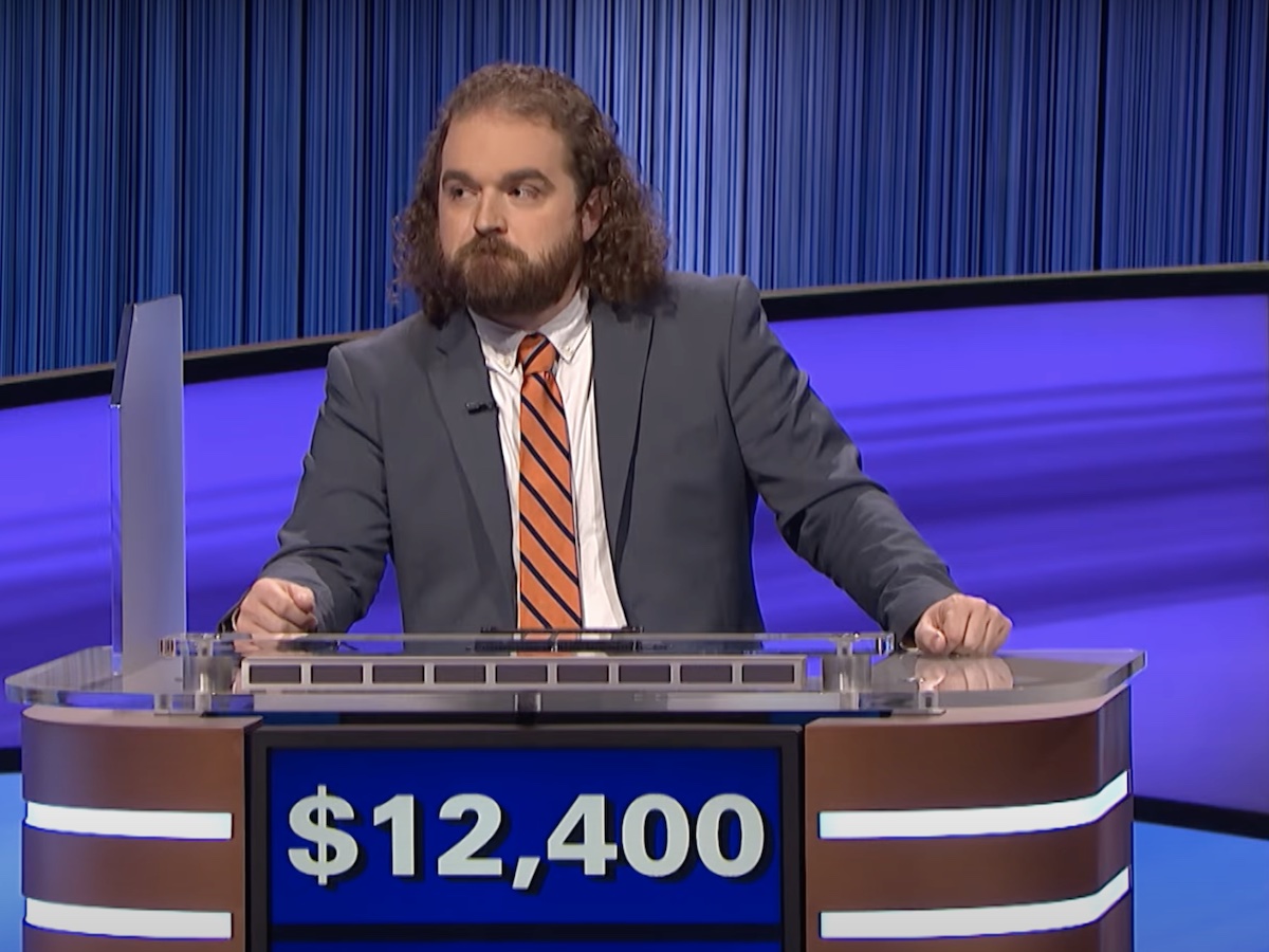 screenshot of Ben Hebert competing on Jeopardy in a blue suit and orange tie