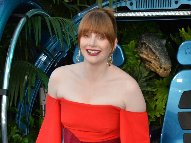 Bryce Dallas Howard smiling in bright red, off-shoulder dress