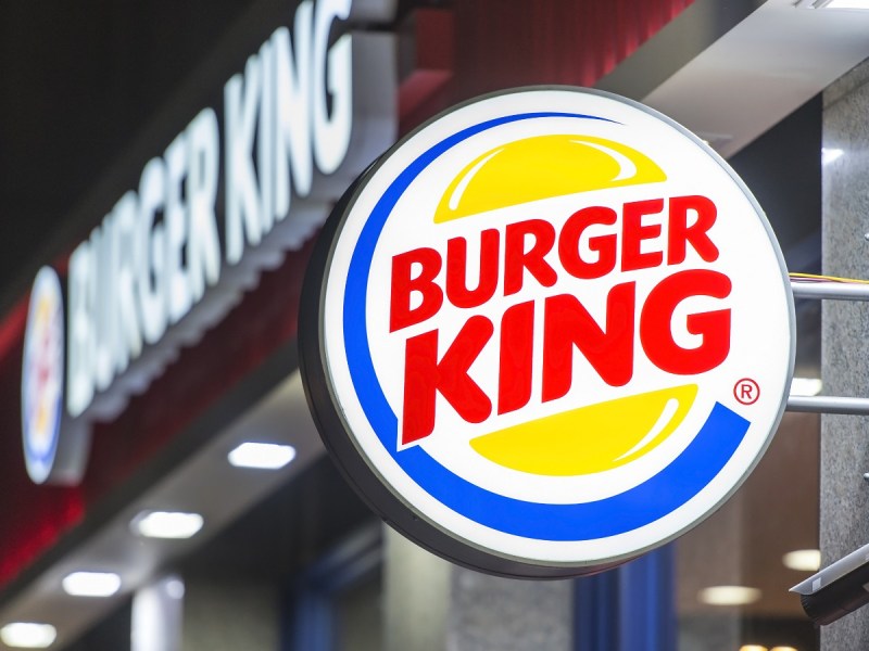 A Burger King sign protrudes from the side of a building at nighttime