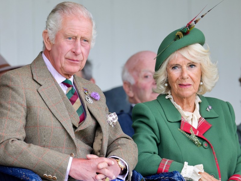 King Charles (L) in tan suit and Camilla Parker Bowles in green jacket with matching hat