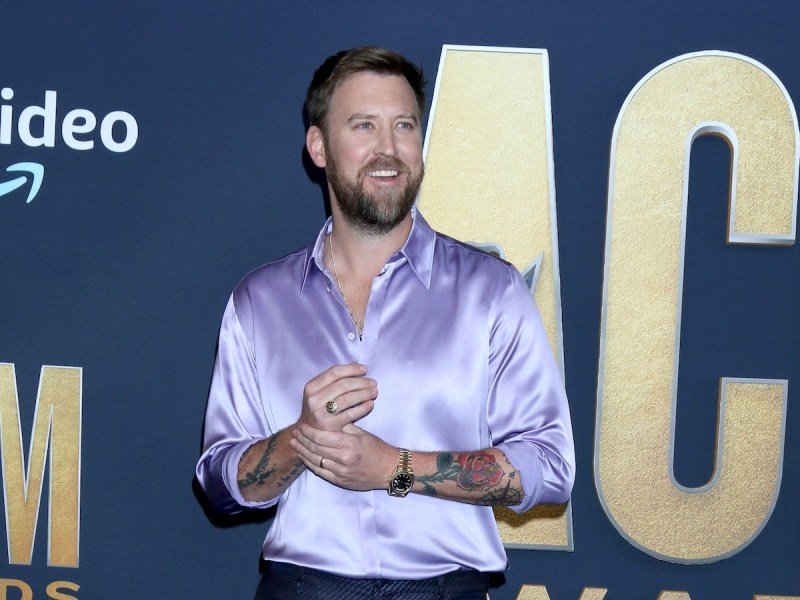 Charles Kelley in a silk purple shirt and navy pants smiling and looking to his left