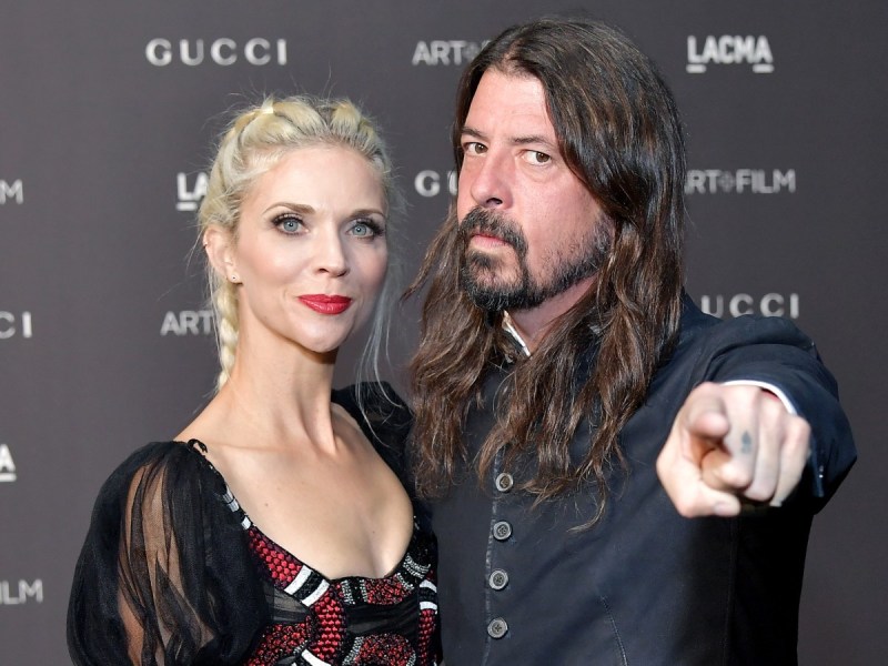 Dave Grohl (R) and Jordyn Blum posing against black backdrop