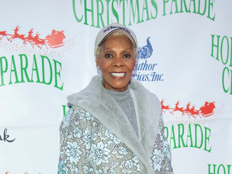 Dionne Warwick smiling in a grey sweater and hat