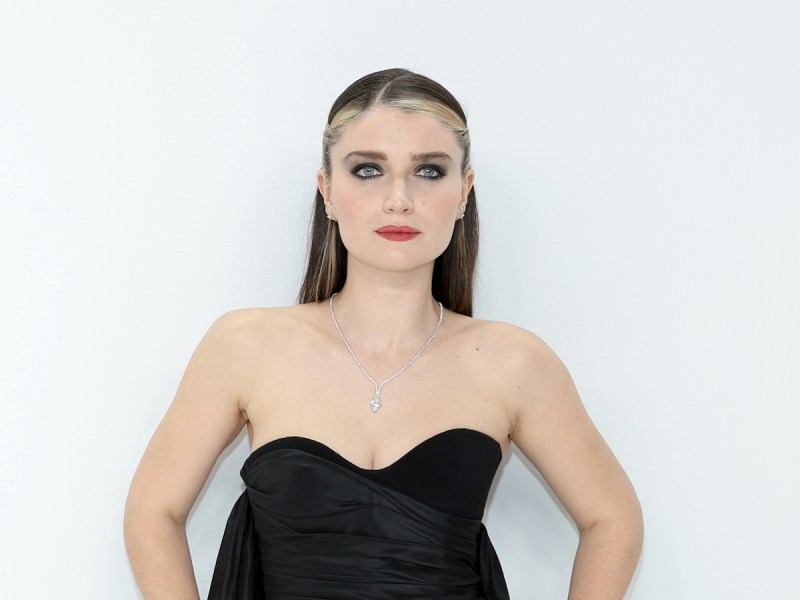 Eve Hewson in a black dress against a white background