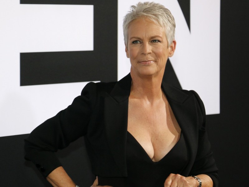 Jamie Lee Curtis poses with both hands on hips wearing all black outfit