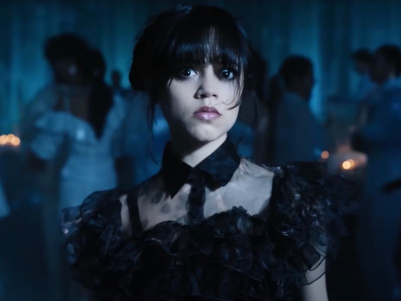 screenshot of Jenna Ortega as Wednesday Addams looking wid-eyed with messy hair at a school dance