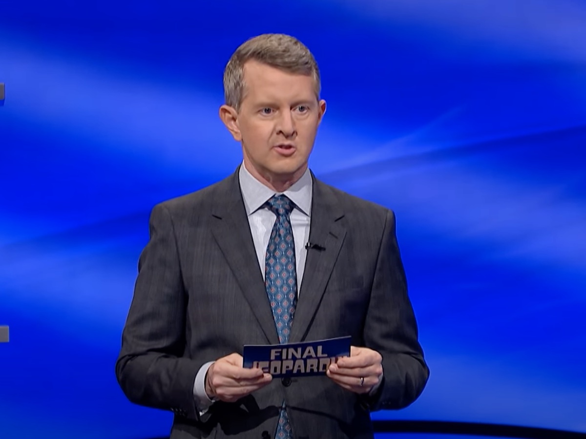 screenshot of Ken Jennings hosting Jeopardy! in a gray suit