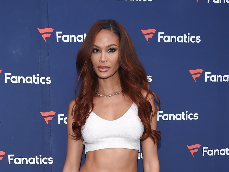 Joan Smalls posing in a white extremely cropped top