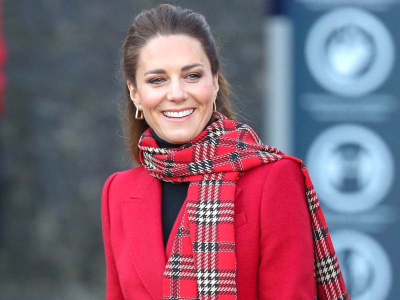 Kate Middleton smiles in red coat and plaid scarf