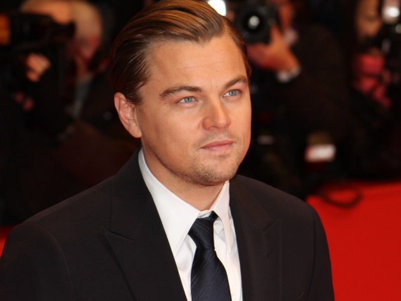 Leonardo Dicaprio smiles on black suit and tie on red carpet