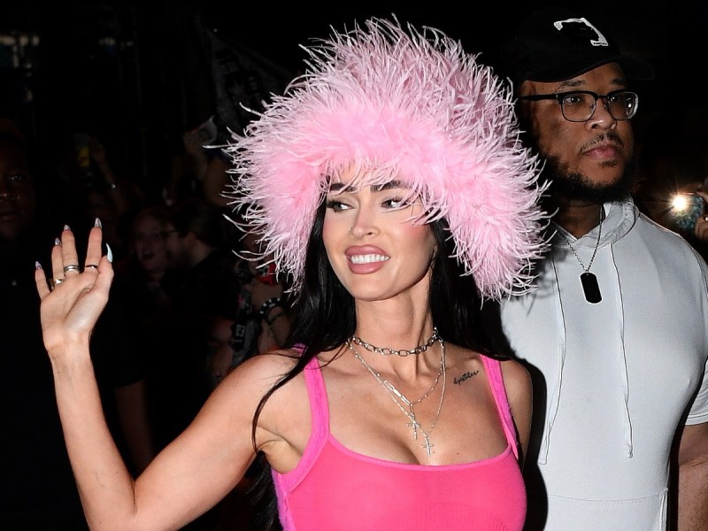 Megan Fox waves in pink fuzzy hat and hot pink crop top