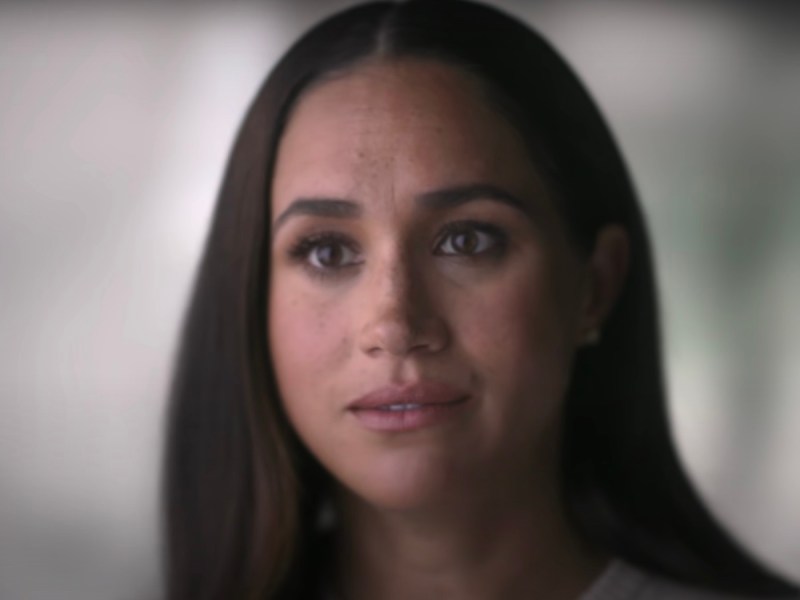 screenshot of a close up of Meghan Markle looking stunned and unhappy in an interview in 'Harry & Meghan'
