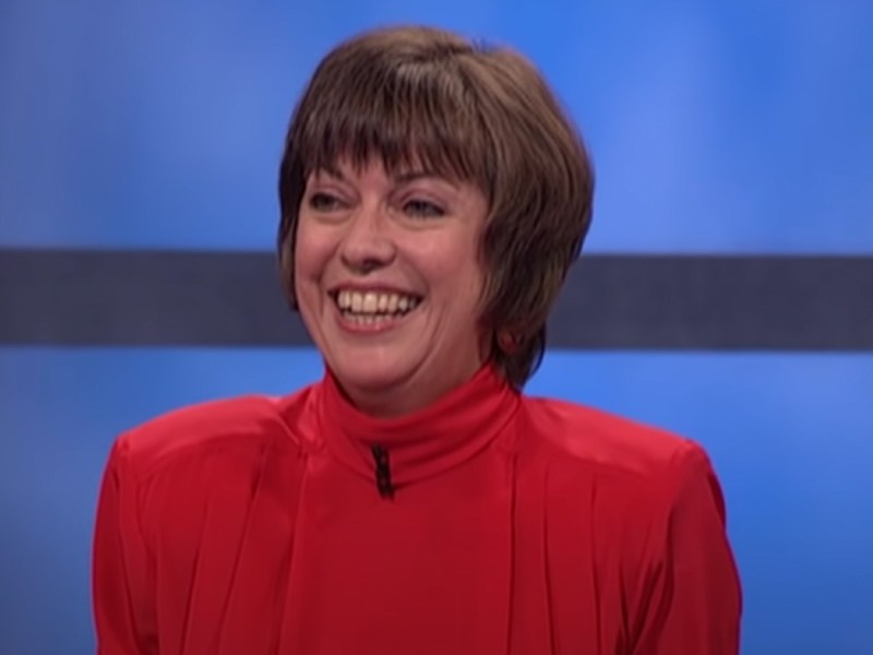 Nancy Zerg smiles in red blouse on 'Jeopardy!' stage