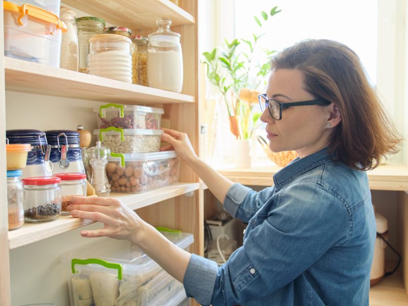 A woman selecting food from a pantry