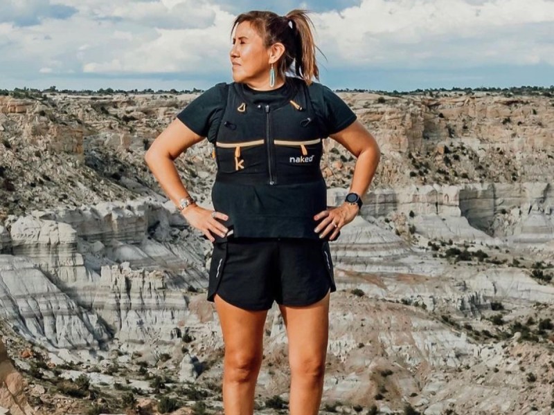 Verna Volker stands outside with hands on hips wearing all black running ourfit