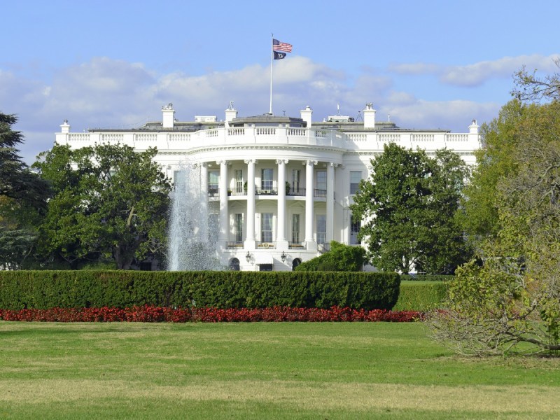 The White House is photographed from a distance on a partly cloudy day