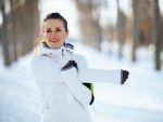 Woman stretching for a workout outside in the snow