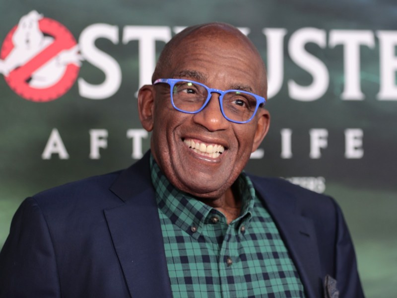Al Roker smiles in navy blue blazer over green and navy plaid top