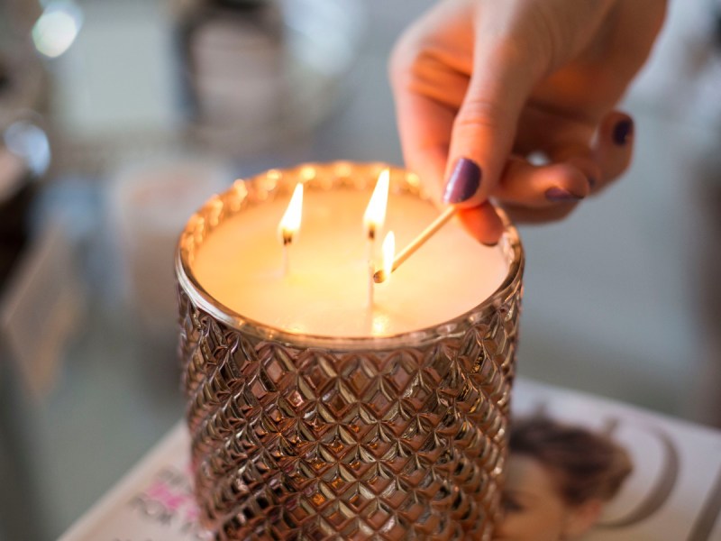 3-wick candle being lit with match