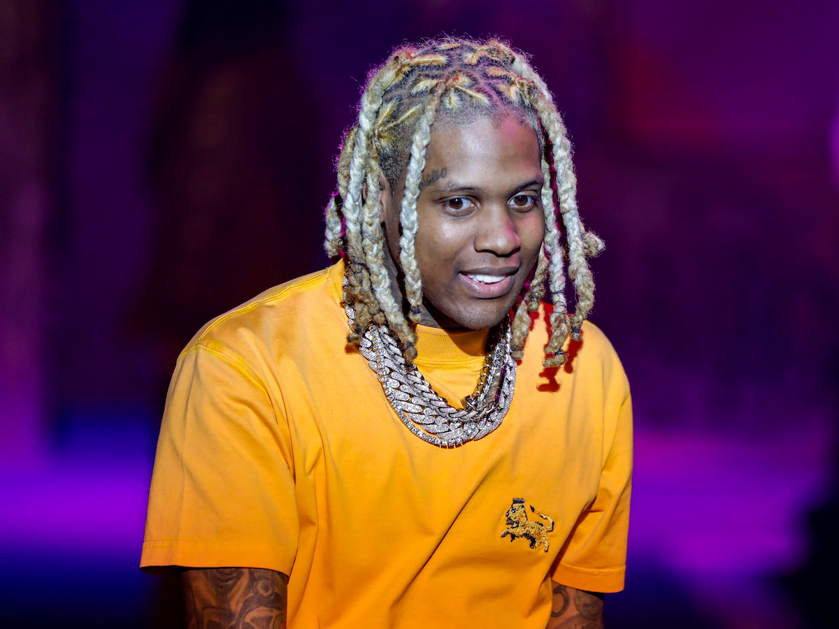 Lil Durk in a yellow shirt performing on a stage