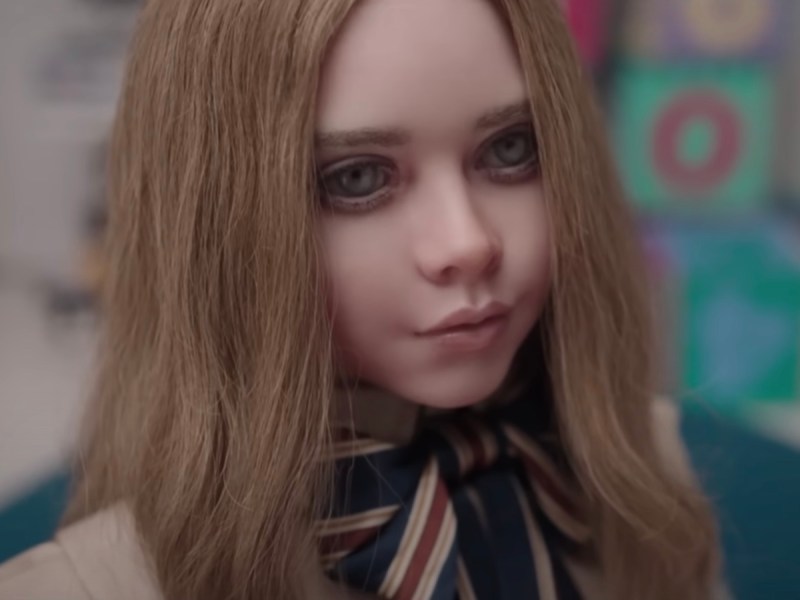 screenshot of the Megan doll from M3GAN smiling and looking creepy
