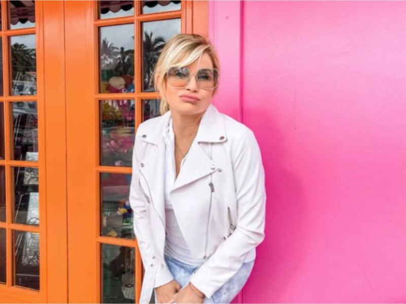 Nadine Caridi, Jordan Belfort's ex-wife, poses in front of a pink wall