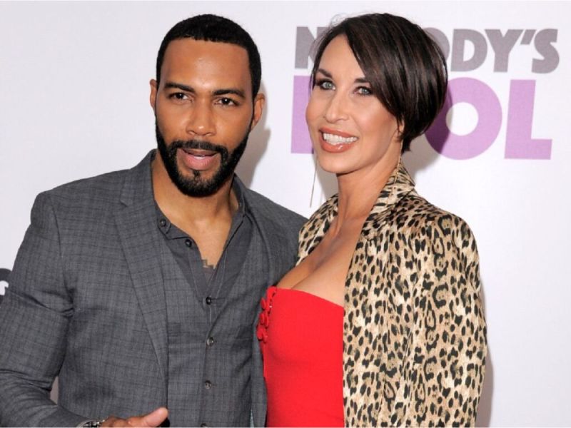 Omari Hardwick and wife Jennifer Pfautch smiling at a red carpet event.