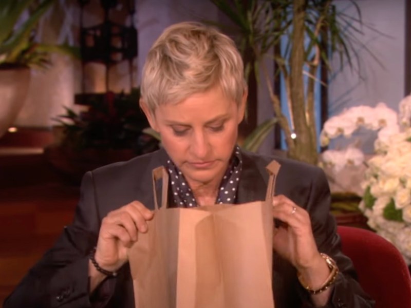 Ellen DeGeneres on her show peering into a brown paper bag