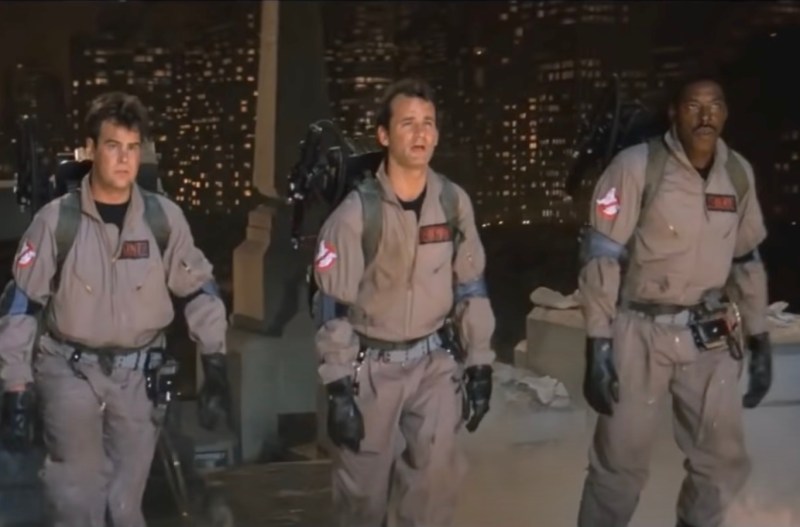 screenshot of the Ghostbusters walking up the courtyard of the Empire State Building in uniform