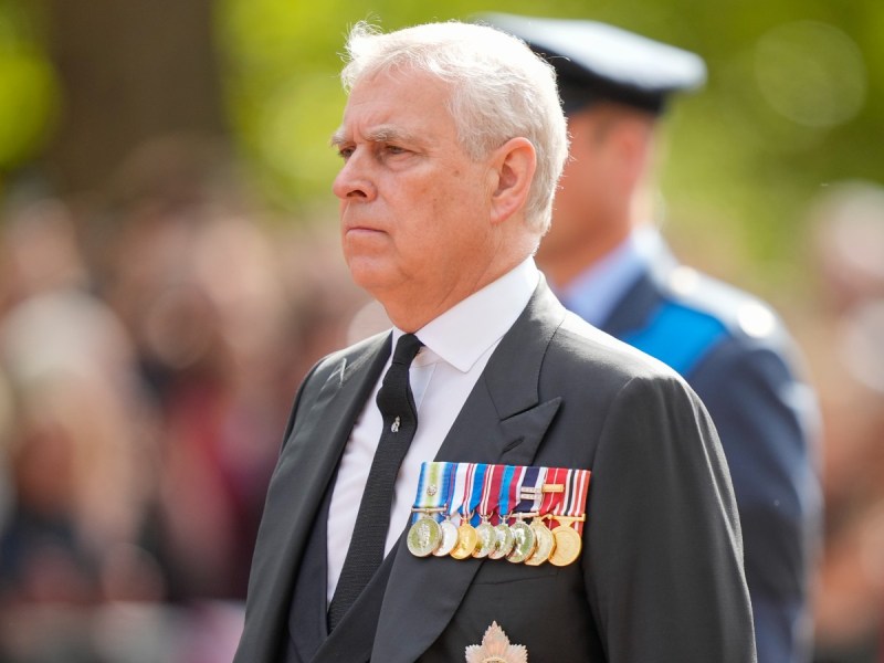 Prince Andrew looking ahead in gray suit and tie