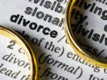 Paper with the definition of divorce and two gold rings on top.