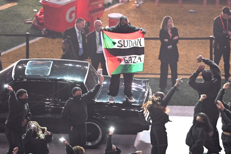 A protestor holds up Palestine and Sudan flag during Kendrick Lamar's Super Bowl LIX halftime show. (Photo by Chandan Khanna / AFP)