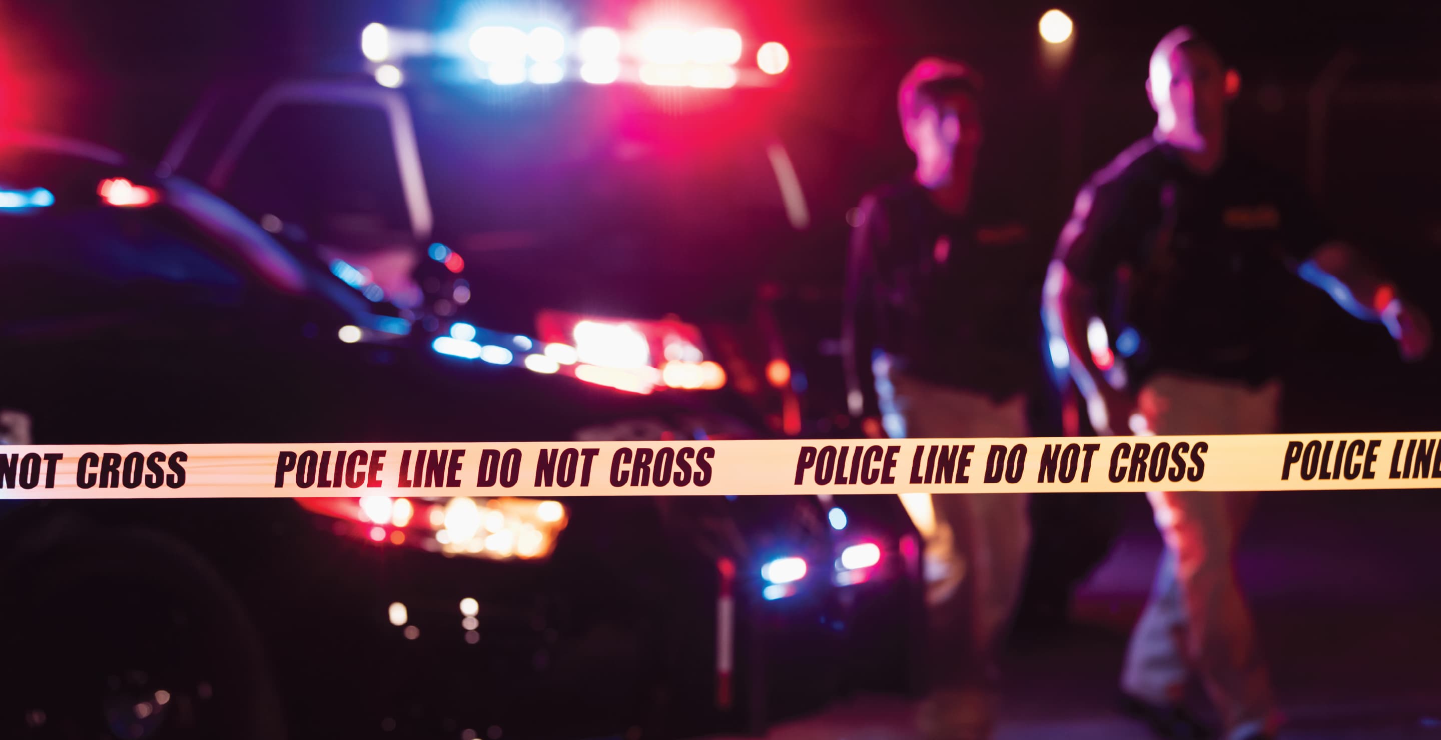 Two Police Officers Behind Yellow Tape