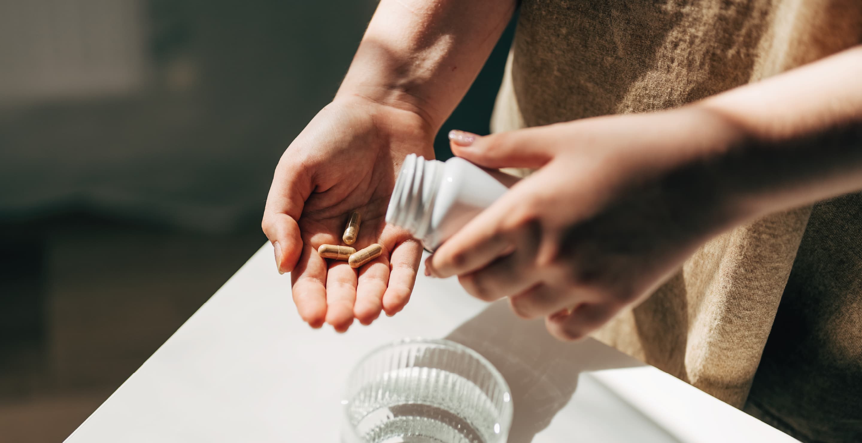 Woman With Pills In Hand And Water Bottle