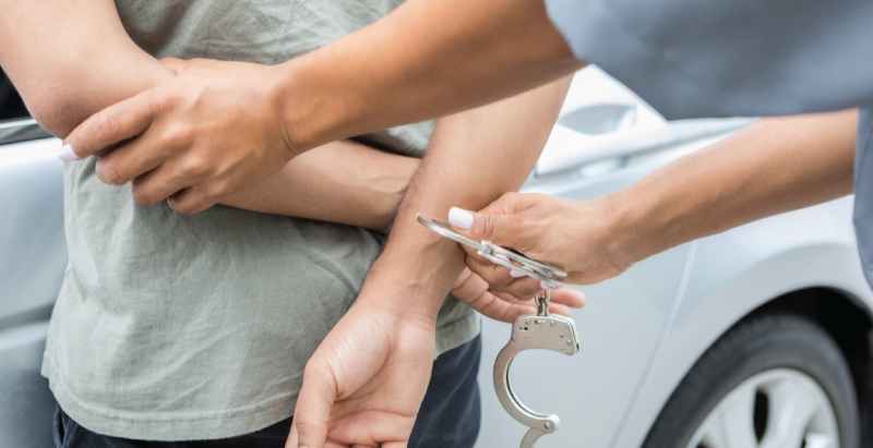 Police Officer Placing Man Under Arrest